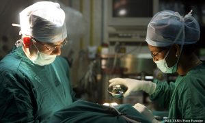 Dr Manoj Kumar J Manwani (L), senior consultant in cosmetic and plastic surgery, and his assistant perform cosmetic surgery inside a hospital operation theater in Mumbai May 9, 2008. For years, Indian women have been relying on the surgeon's knife for that perfect body, that flawless face, and now, the men are muscling in. Body enhancing procedures are no longer only for the female, the self-conscious or the wealthy, with India's economic boom spawning a new breed of male, middle-class professionals with the desire to look good and the money to make it happen. To match Reuters Life! INDIA-MEN/SURGERY REUTERS/Punit Paranjpe (INDIA) - RTX5Z46